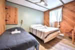 Wood-finished bedroom with double bed & single bed