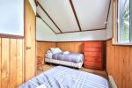 Alternate angle of twin beds with pine wall accents