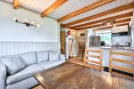 Living and dining space with comfortable seating and rustic wood table.