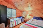 Lakeview Cabin bedroom with wood-paneled interior and two single beds.