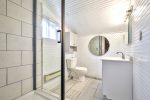 enovated bathroom in the Lakeview Cabin with walk-in shower, vanity, and round mirror.