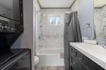 Modern bathroom with bathtub, washer & dryer