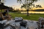 Firepit set directly on the shoreline with chairs at sunset.