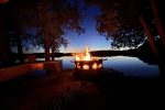 Firepit area beside the Lakeview Cabin with bench at dusk.