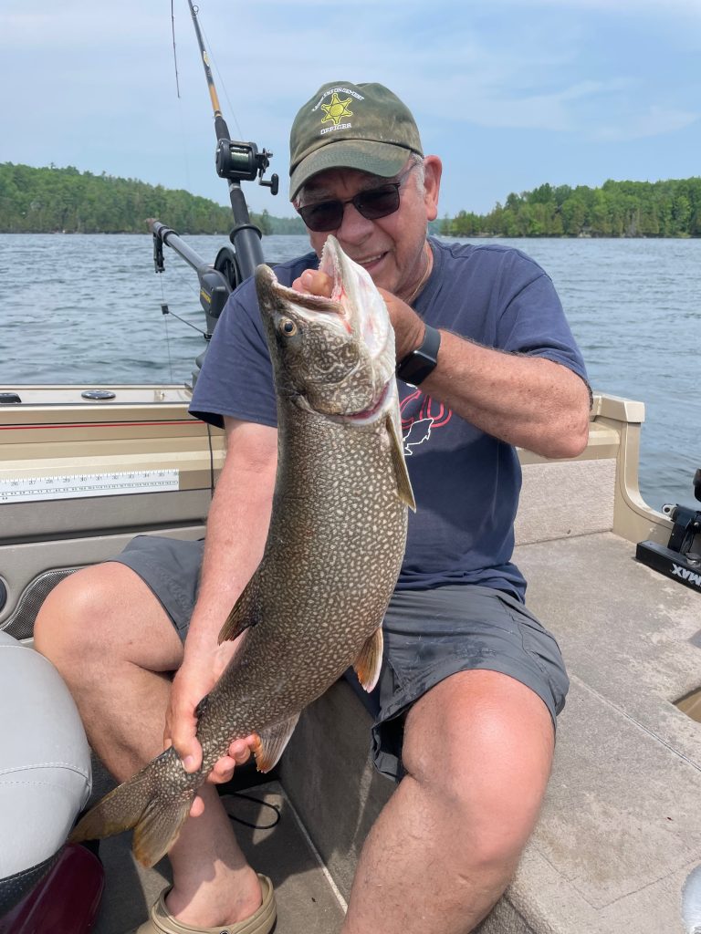 Pêcheur montrant un touladi fraîchement attrapé sur le lac Heney, Québec, près des chalets R&B Retreats